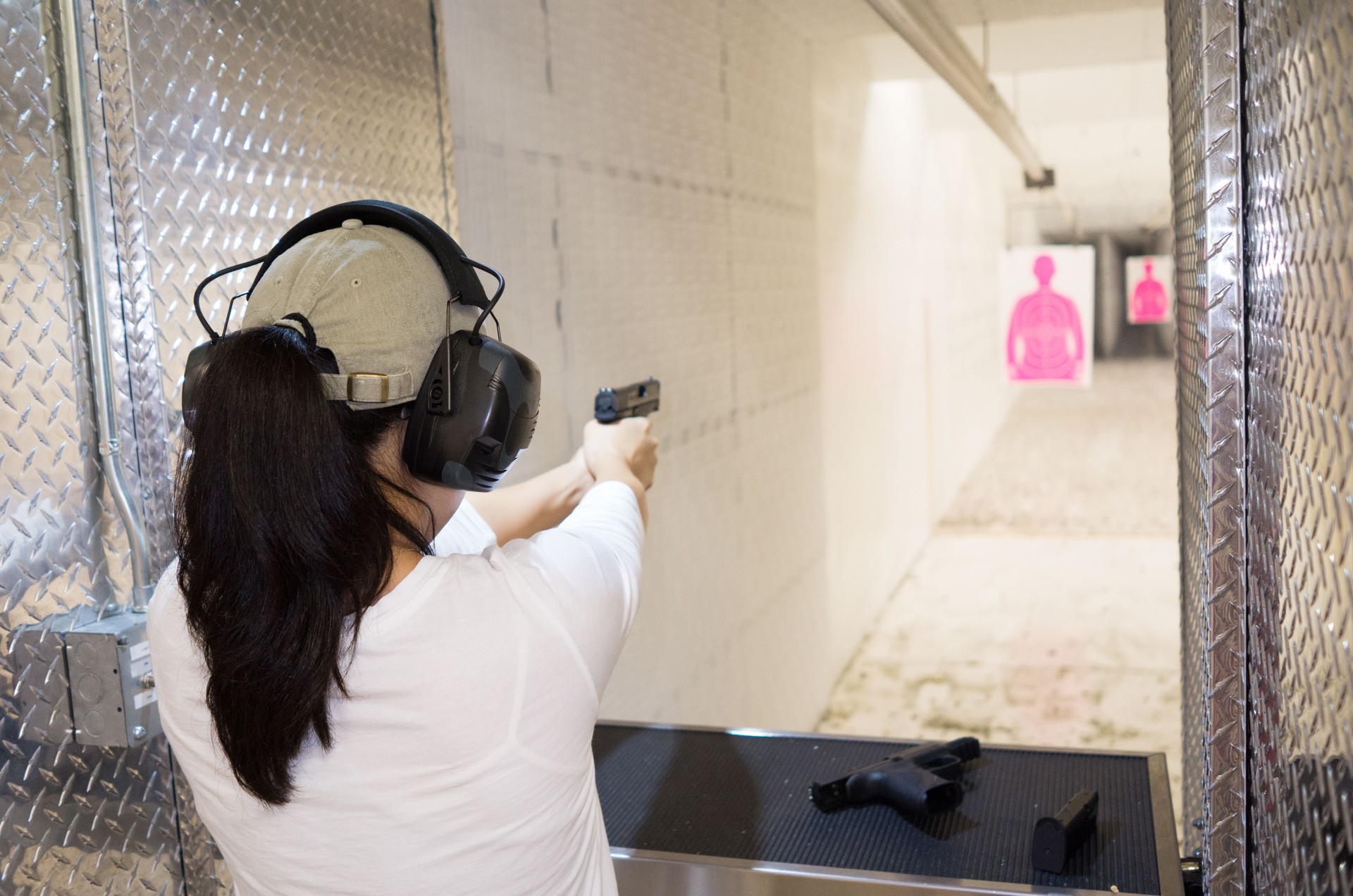 young woman target shooting at gun range